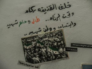 كتبوا هذه العبارة على أحد جدران سوريا. اقتبستها حنين بنفس الخط والألوان وكتبتها على جدار غرفتها، لعلّها تنقذ هذه الكلمات من الحرب.